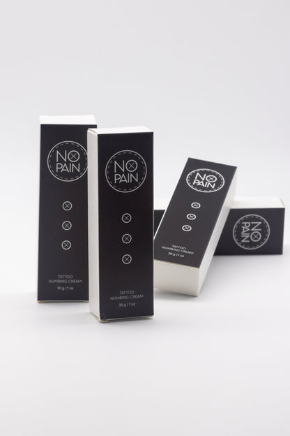 Boxes of "No Pain Tattoo Numbing Cream" from My Store are arranged on a white background. The black boxes with white text highlight "No Pain Tattoo Numbing Cream" and indicate the product size—30g or 1 fl oz. Promising pain-free tattooing, two boxes stand upright while two lay flat, ensuring tattoo comfort at your fingertips.