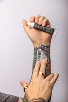 Applying No Pain Tattoo Numbing Cream to skin before a tattoo session.