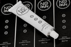 No Pain Tattoo Numbing Cream 100ml / 1 oz tube artistically laid on top of the product box.